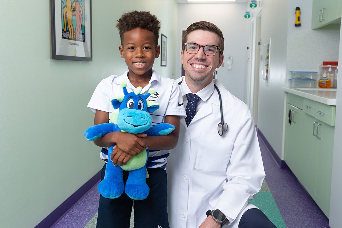 A pediatric physician at a primary care office in Anna, Texas is smiling with a kid