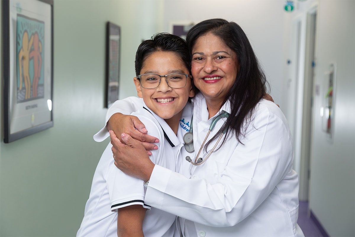 A primary care physician hugging a child at a pediatric office in Ennis, Texas