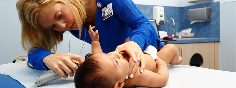 Nurse practitioner examining baby