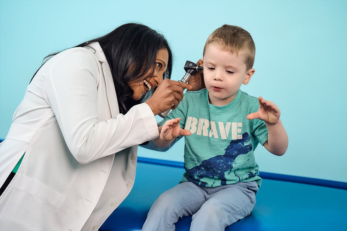 A pediatrician in Lewisville examining a young boys’ ears