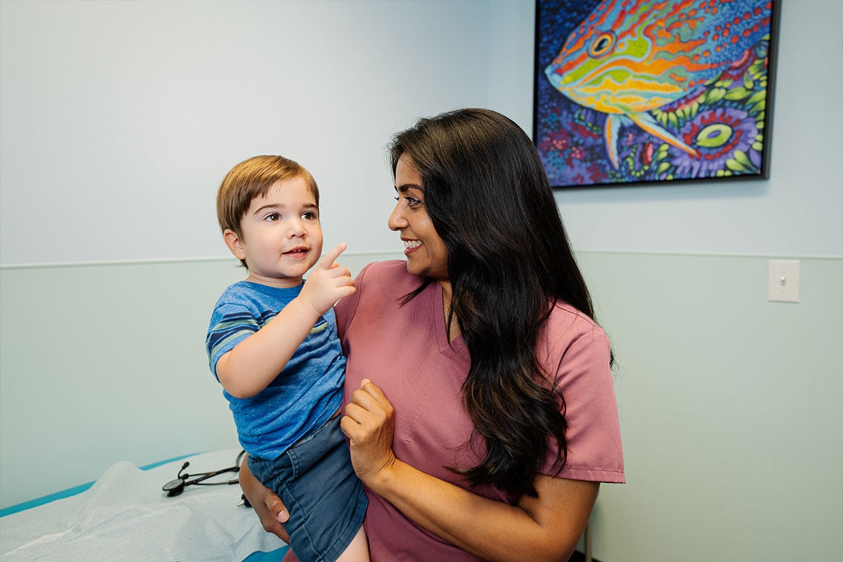 Pediatric physician performing a wellness check on a young child