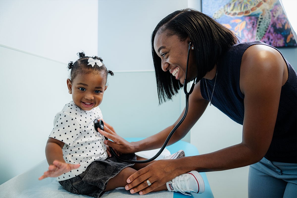 Pediatric physician examining a young child’s heart at a pediatric primary care office